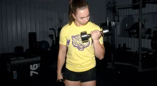 Female athlete curling with a Hampton Chrome Beauty-Grip Dumbbell