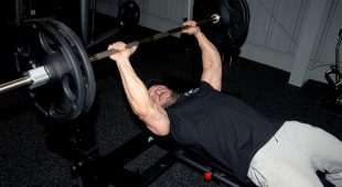 Weightlifter performing a bench press using Hampton Olympic Grip Plates.