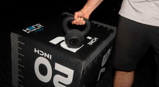 Image of a weightlifter gripping a Hampton urethane kettlebell.