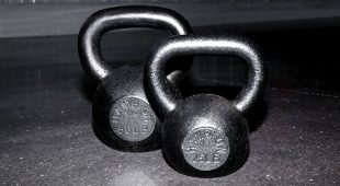 Front view of a set of Hampton Urethane kettlebells resting on a gym floor.