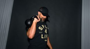 A weightlifter holding a black powder coated Hampton kettlebell.