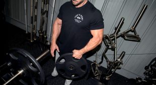 Weightlifter holding a Hampton Olympic Grip Plate with one hand.