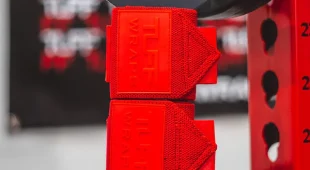 Stacked view on weights of Tuff Wraps villain sidekick wrist wraps in solid red colorway.